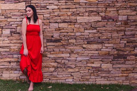 Fotografia feminina. Ensaio realizado na ilha do frade. Fotografia feita num muro de pedra. Modelo com pé apoiado na parede.'