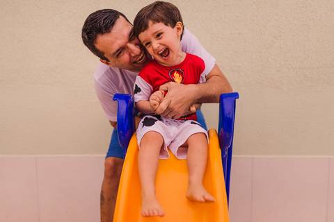 Pai fazendo casquinha no filho. Fotografia de família em Vila Velha, ES - Itapuã.'