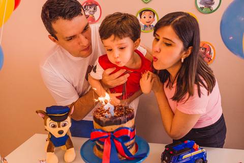 Momento de assoprar o bolo no aniversário infantil. Fotografia de Aniversário. Documental de família em casa.'