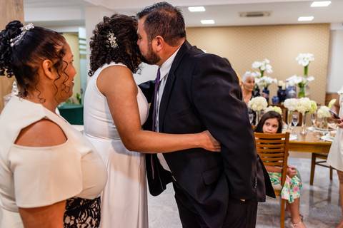 Noivo abraçando a noiva ao recebê-la no altar.'