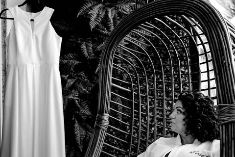 Noiva sentada olhando para o vestido de noiva - Fotografia de Casamento - Making Of Casamento - Vitória ES'