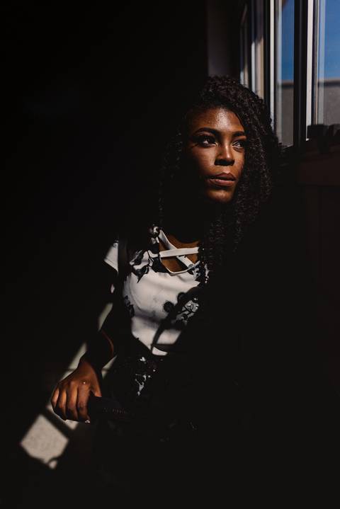 Retrato de uma aluna universitária. Luz de janela entrando em seu rosto. Ensaio fotográfico de formatura'