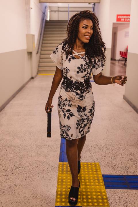 Fotografia de Formatura Multivix. Formanda andando pelos corredores da faculdade.'