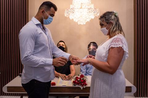 Fotografia realizado no momento em que os noivos estao trocando alianças no cartório. casamento no cartório'