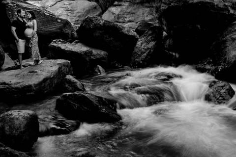 Fotografia preto e branco do ensaio de gestante na cachoeira.'