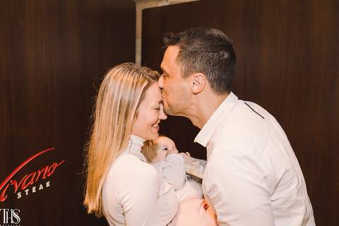 pais com bebê no colo marido beijando testa de esposa batizado - fotografa em sp sbc abc'