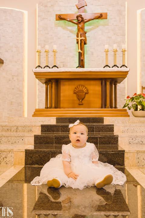 bebê olhando para câmera em batizado sentada no chão da igreja - fotografa em sp sbc abc'