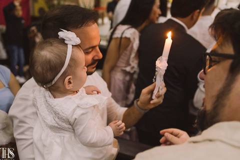 padrinho mostrando vela para bebê em batizado - fotografa em sbc'