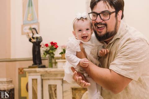 bebê no colo de pai rindo em batizado - fotografa no abc'