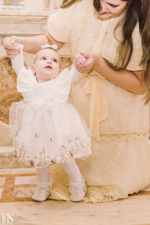 mãe segurando mãozinha de bebê em batizado - fotografa em santo andré'