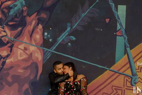 Foto de casal sentado na parede com grafite em São Bernardo do Campo - SP'