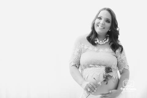 Foto gestante segurando uma flor e a barriga'