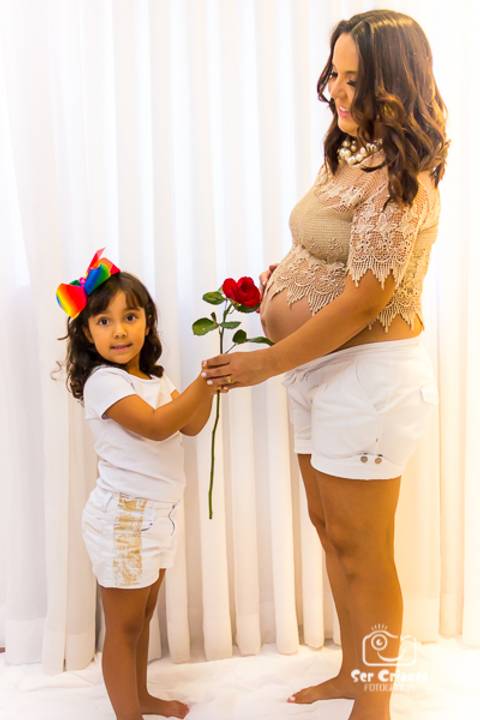 Filha entregando flor para a mamãe gestante'