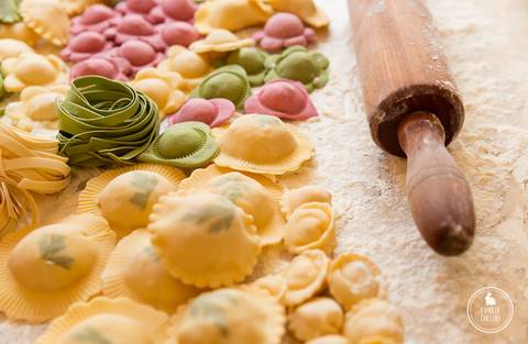 Imagem de massa fresca, com farinha e rolo de madeira.'