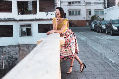 modelo feminina debruçada sobre parapeito da ponte'