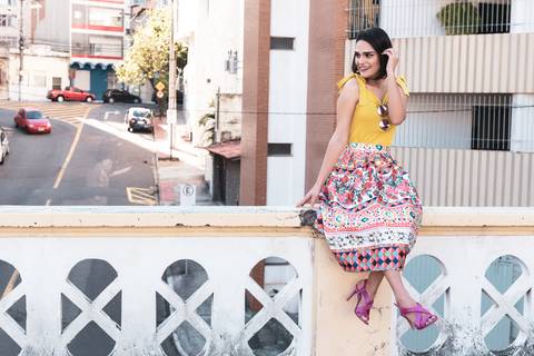 modelo feminina sentada sobre parapeito na ponte'