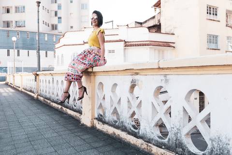 modelo sentada sobre parapeito da ponte'