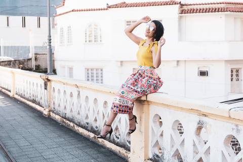 modelo sentada levanta os braços'