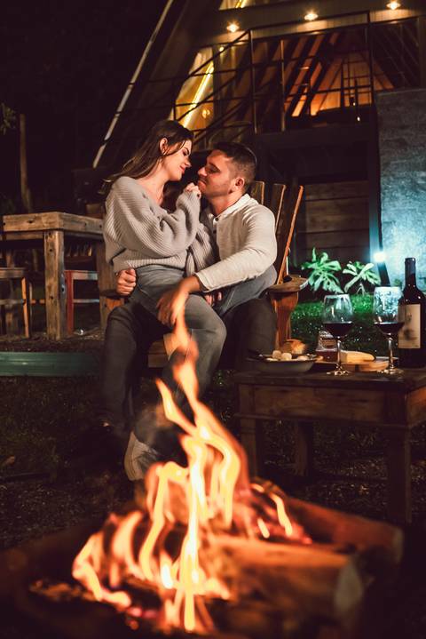 Casal na natureza com fogo de lareira'