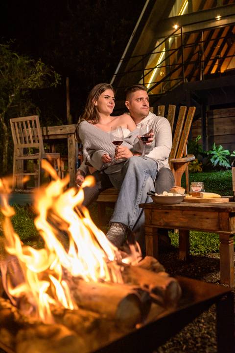 Casal na natureza com fogo de lareira'