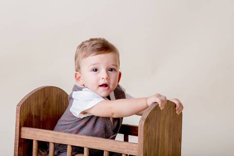 bebê sorrindo em ensaio de acompanhamento de 9 meses'