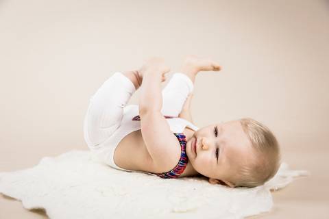 bebe de seis meses, barriguinha pra cima, segundando o pé, acompanhamento primeiro ano'