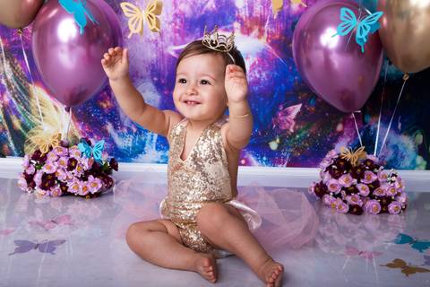 Felicidade no ensaio smash the cake, jardim de borboleta, cor predominante roxa.'