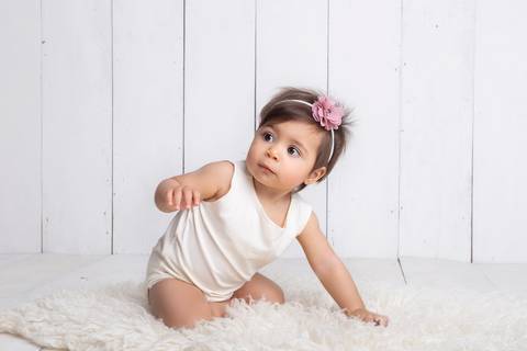 Fofura em cenário minimalista, clean, branco e atemporal em seu ensaio de acompanhamento primeiro ano'