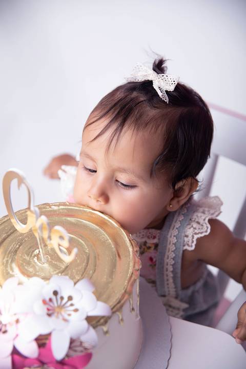 Detalhe de comendo o bolo no ensaio smash the cake rosa'