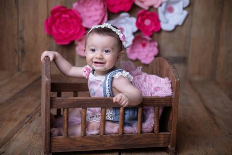 Bebê de seis meses no bercinho, rosa, acompanhamento trimestral Brasilia DF'