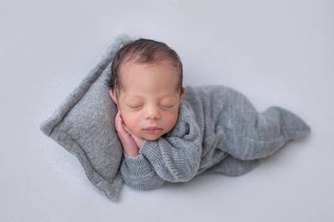 dorminhoco newborn em manta branca'