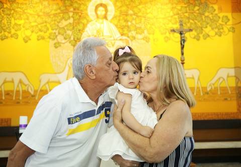 fortos batizado no altar da igreja: com padre e família, pais, padrinhos, avós, tios '