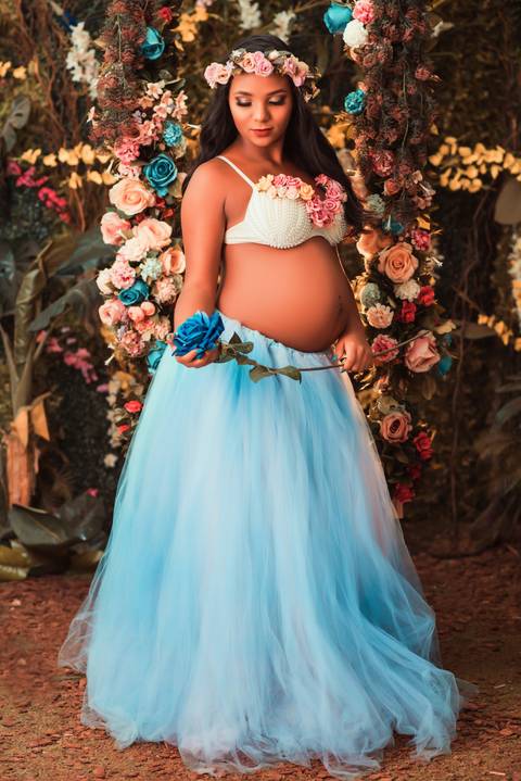 A expressão radiante de Julia, combinada com o cenário de jardim, cria um contraste hipnotizante, transmitindo uma sensação de mistério e fascínio.'