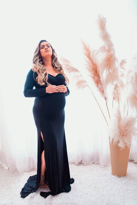 A beleza natural da futura mamãe se destaca no cenário clean, com tons suaves e uma atmosfera serena que reflete sua tranquilidade interior.'