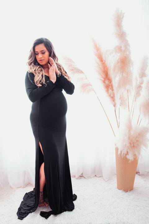 Uma foto no cenário clean revela a expectativa e a emoção nos olhos da gestante, enquanto ela aguarda ansiosamente a chegada do seu bebê.'