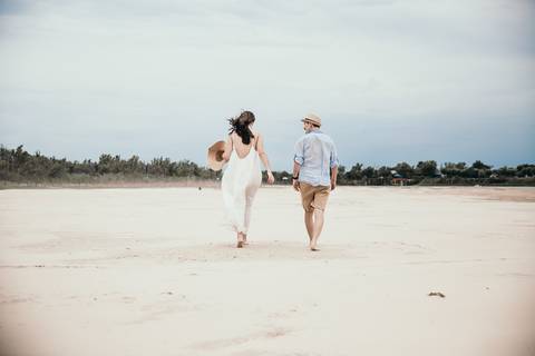 pareja caminando en la playa con sombrero. Sesion de fotos Erika Fayolle'