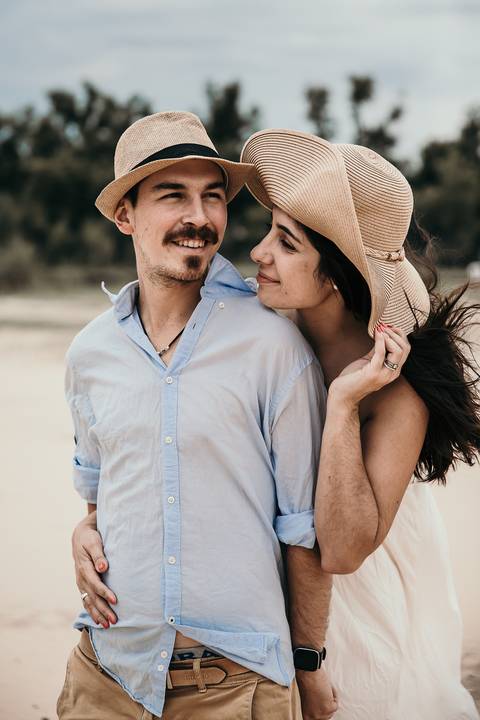 Pareja enamorada con sombrero en la playa. Sesion pre boda erika fayolle'