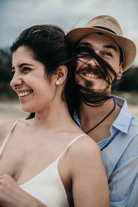 Pareja enamorada con sombrero en la playa. Sesion pre boda erika fayolle'