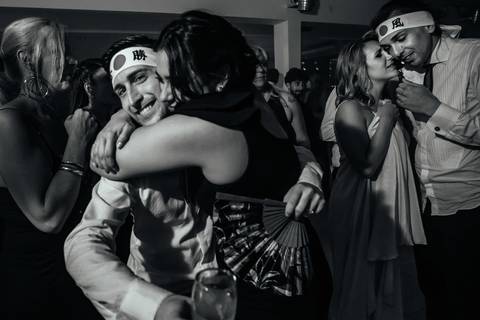 Novio y amiga abrazados en la fiesta de su casamiento igualitario en Sky Blue, Rosario.'