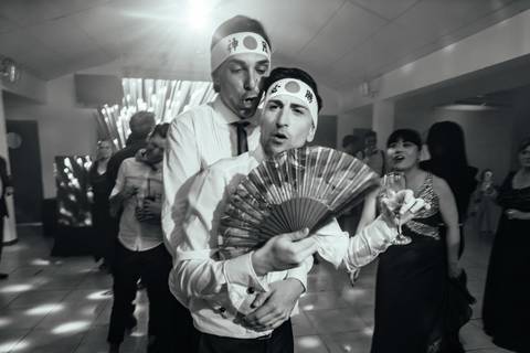 Novios con abanico oriental en su boda temática. Casamiento igualitario.'