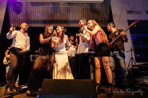 Show musical en la fiesta de casamiento de Punta Barranca Rosario. Novios cantan en el escenario.'