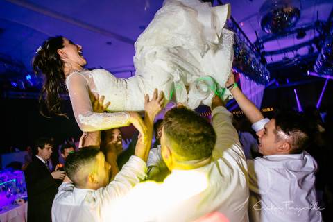 Novia en el aire con amigos en su casamiento. Punta Barranca, Rosario.'