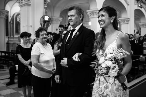 Novia entrada con el padre a la iglesia. Foto blanco y negro.'