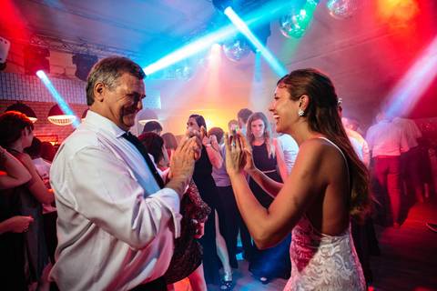 Novia con el papá en la fiesta de su boda.'