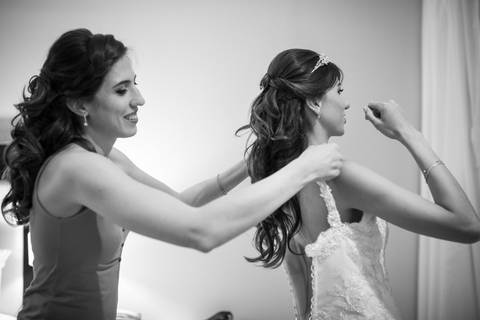 Hermana y novia poniendo el vestido antes de la boda. Fotografo de bodas Erika Fayolle en Rosario, Buenos Aires.'