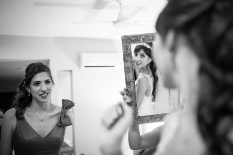 Hermana de la novia mirando en el espejo con vestido. Fotografía Fotografo de bodas Erika Fayolle en Rosario, Buenos Aires. blanco y negro.'