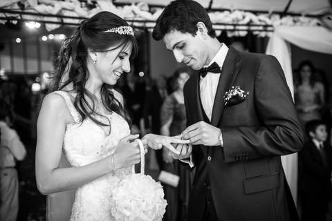 Anillos para los novios después de la bendición en la ceremonia de su boda. Foto blanco y negro. Fotografo de bodas Erika Fayolle en Rosario, Buenos Aires.'