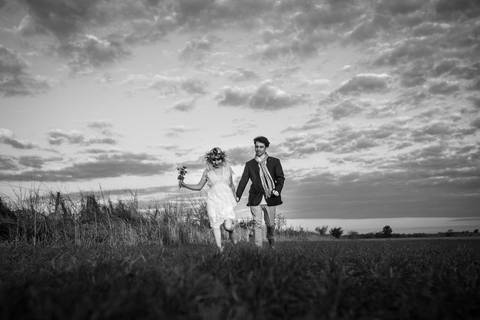Foto blanco y negro en el campo. Pareja de novios jugando. Book Erika Fayolle'