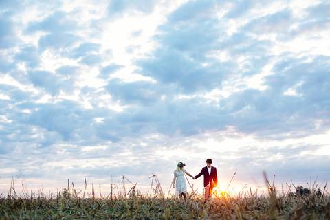 Novios caminando en el campo en la sesión de fotos. Atardecer en el campo. Fotografia Erika Fayolle'