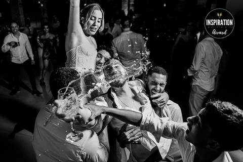 Cena vibrante de festa de casamento, com amigos e noiva celebrando em um momento espontâneo de alegria. A energia e emoção deste instante, com a água no ar, capturam a essência da diversão e celebração.'